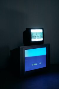 photo of black crt tv turned on in a dark room